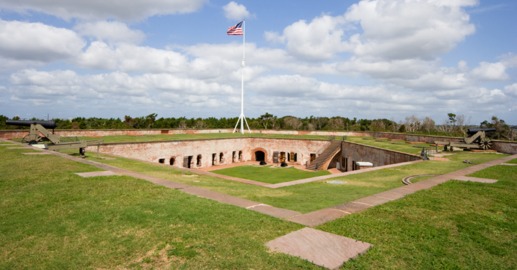 Picture of the top of Fort Macon with cannons pointing out and a flag in the center 