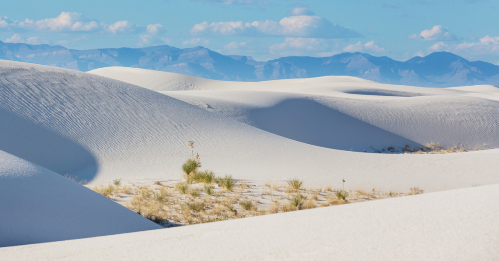 White gypsum dunes at the bottom of a mountain range